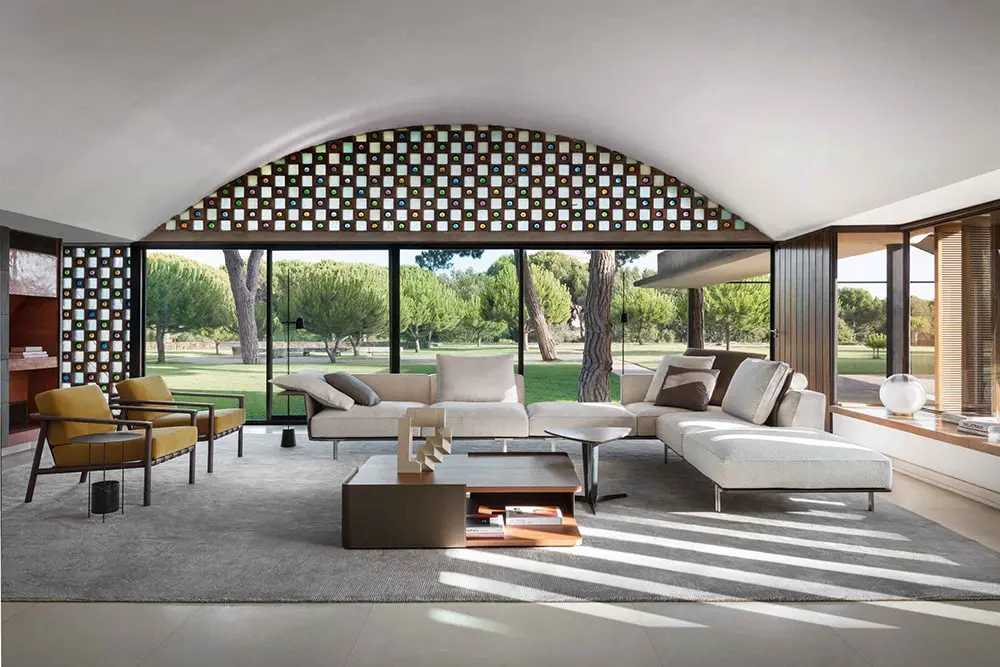 Barrel-vaulted living room with mosaic-tiled arch, mustard chairs and beige sectional sofa
