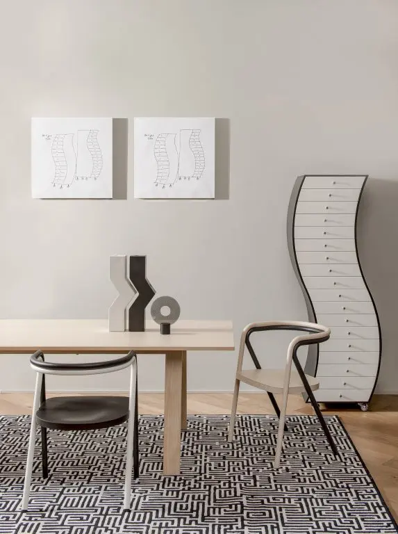 Dining set with wood table, patterned vase and a curved wave-shaped cabinet on wheels