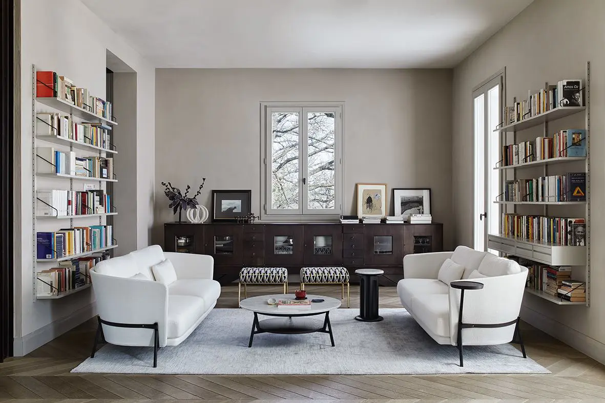 Arflex living room with two white sofas facing each other, a round coffee table and wall bookshelves