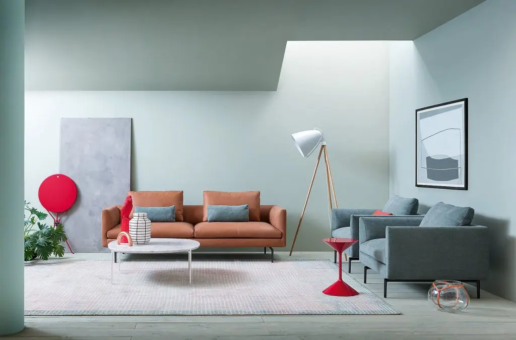 Zanotta contemporary living room with a terracotta leather sofa, blue-grey armchairs and a white tripod floor lamp