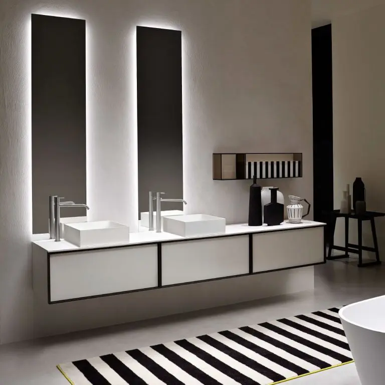Antonio Lupi bathroom with a white pedestal basin, two backlit vertical mirrors and a striped black and white rug