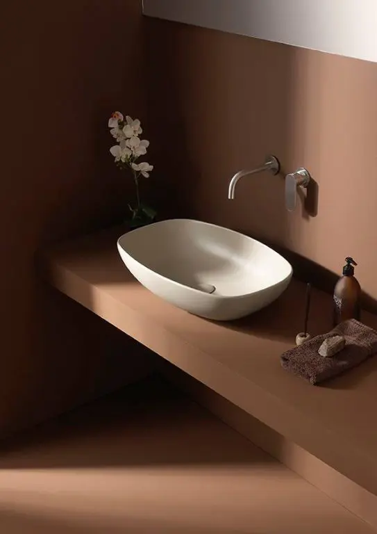Ceramica Flaminia terracotta-toned bathroom with an oval countertop basin, wall-mounted tap and an orchid
