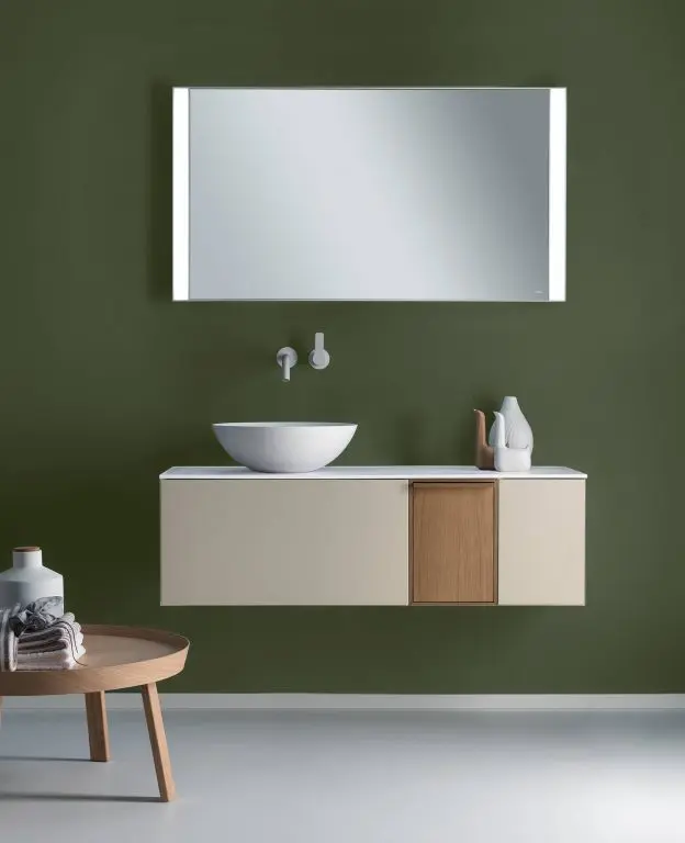 Falper green-walled bathroom with a floating vanity, round countertop basin and a backlit mirror