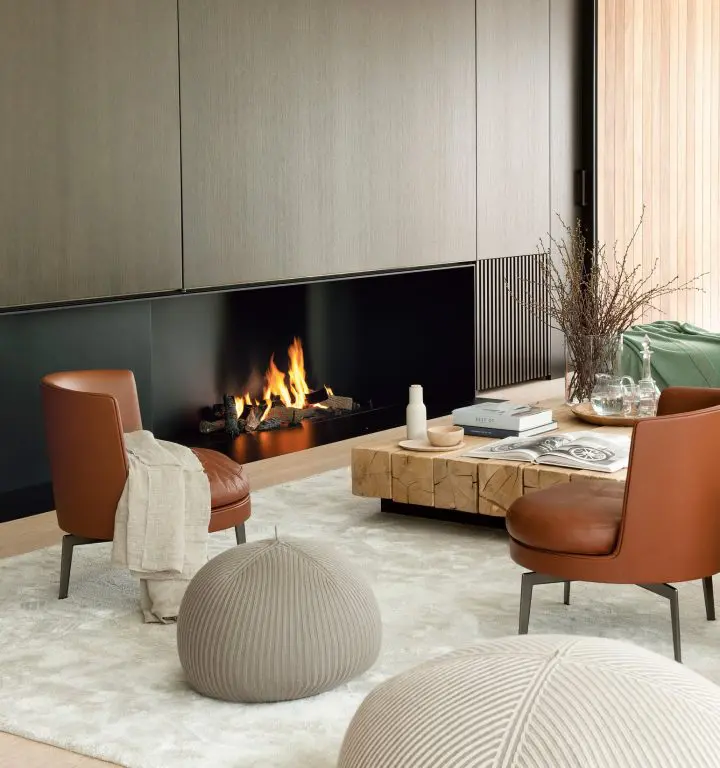 Flexform contemporary living room with tan leather armchairs beside a built-in fireplace and a solid wood coffee table