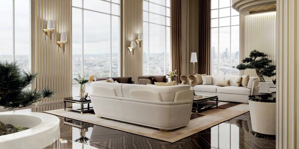 Turri living room with a cream curved sofa, gold wall sconces, a bonsai tree and floor-to-ceiling windows over a city skyline
