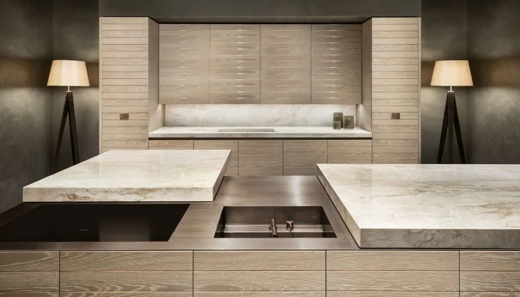 Armani/Dada kitchen with light wood cabinetry and a thick stone countertop island
