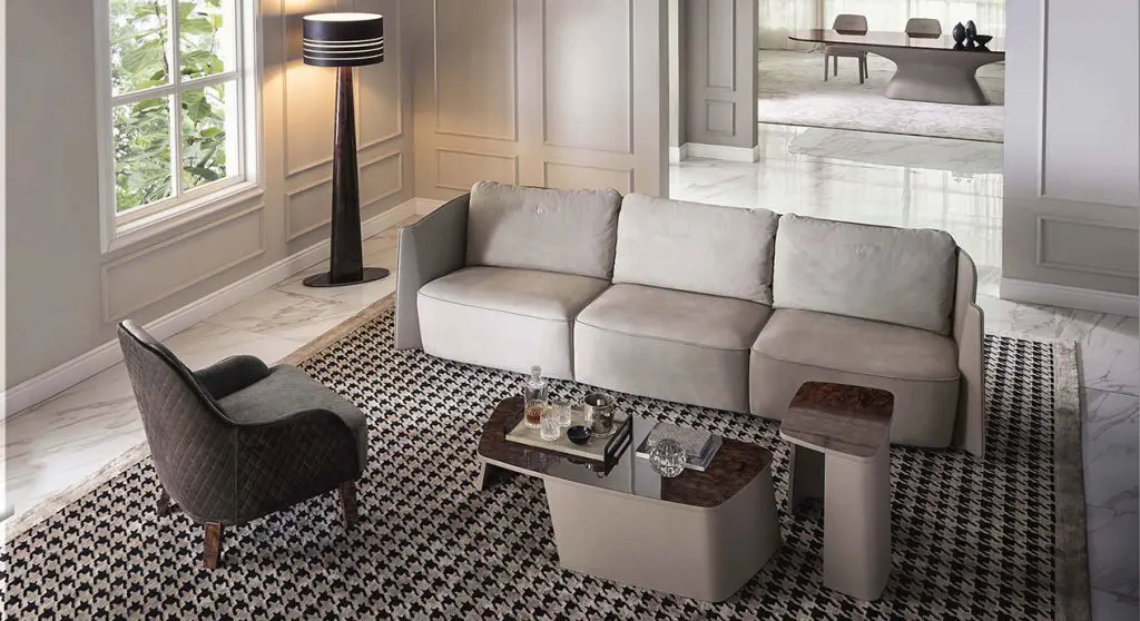 Bentley Home living room with a taupe leather-trimmed sofa, quilted armchair and houndstooth rug on marble flooring