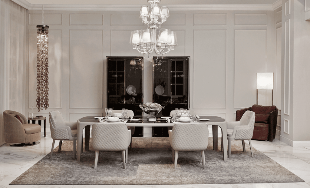 Bentley Home dining room with a table set for dinner, cream quilted chairs and a crystal chandelier