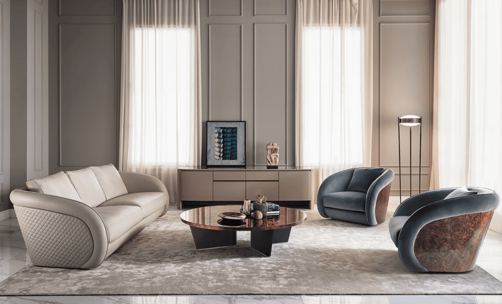 Bentley Home living room with a quilted beige leather sofa and teal swivel armchairs with wood burl backs
