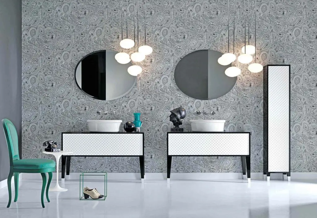 Falper black and white bathroom with twin vanities, round mirrors, cluster pendant lights and a teal chair