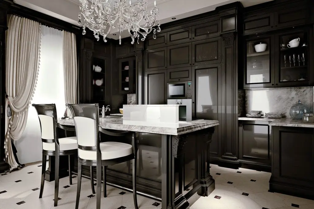 Provasi black kitchen with a marble island, cream upholstered bar stools and a crystal chandelier