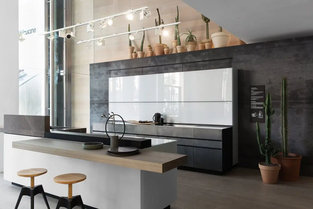 Valcucine Artematica kitchen display with grey cabinetry and terracotta pots of cacti on an overhead shelf