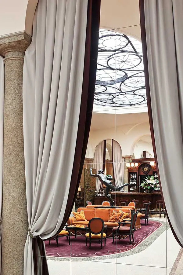 Curtained view down into a domed lounge with orange armchairs