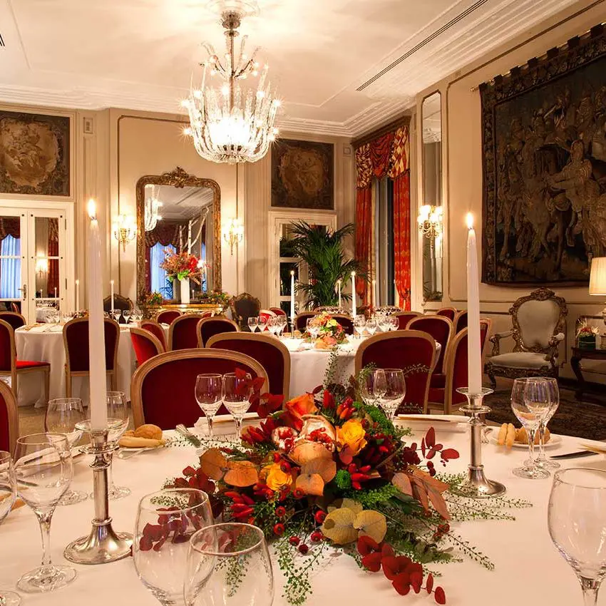 Formal dining room set for a banquet with chandelier and wall tapestries