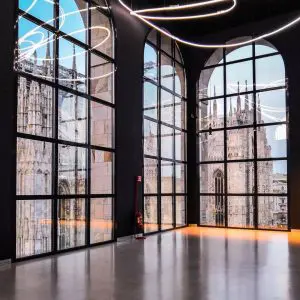 Glass atrium windows reflecting the Duomo's spires