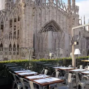 Rooftop restaurant terrace set with tables beside the cathedral's carved stone facade