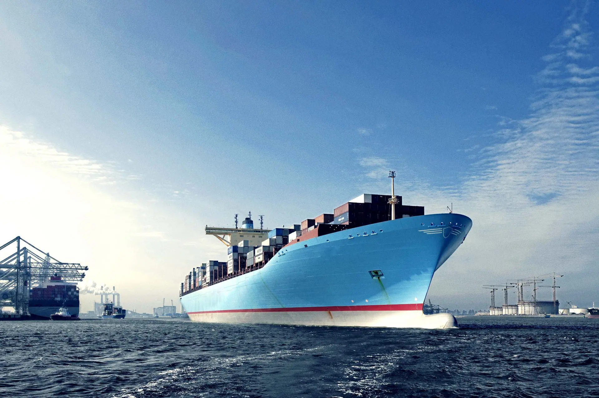 Blue cargo container ship entering a harbor