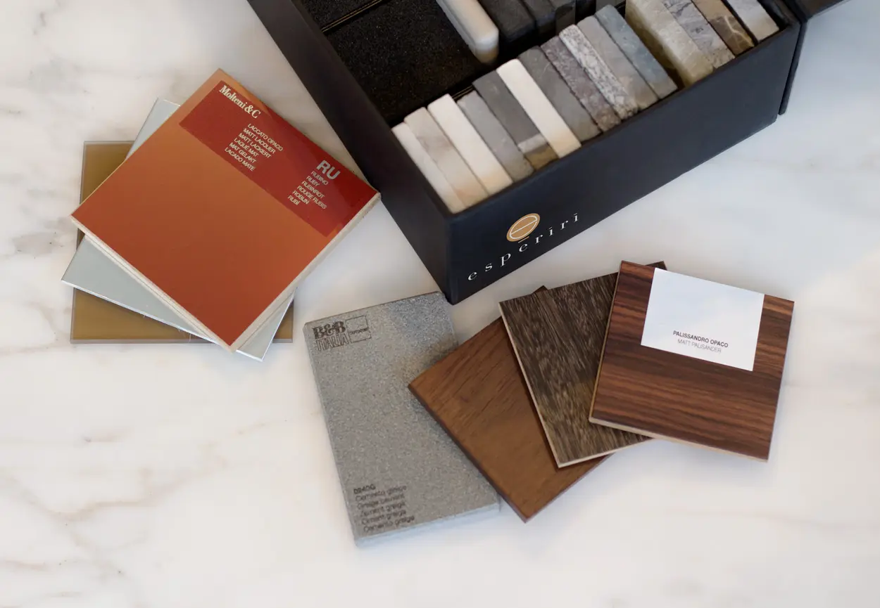Fabric, wood and stone material sample books beside an esperiri branded swatch box on marble