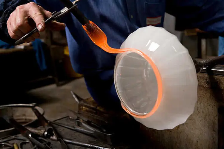 Glassblower shaping a glowing molten glass bowl