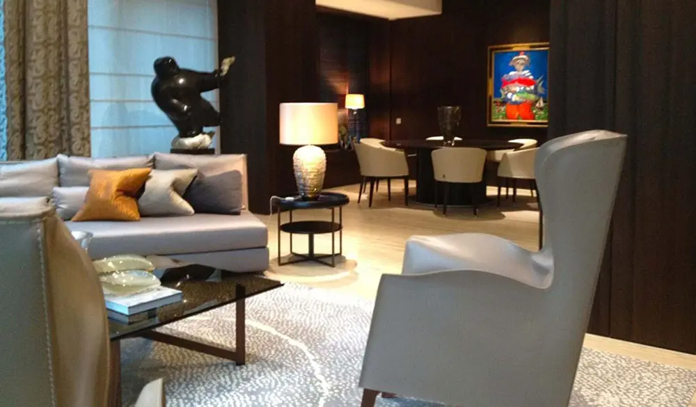 Sitting room with a wingback chair, a black sculpture and a colorful framed artwork
