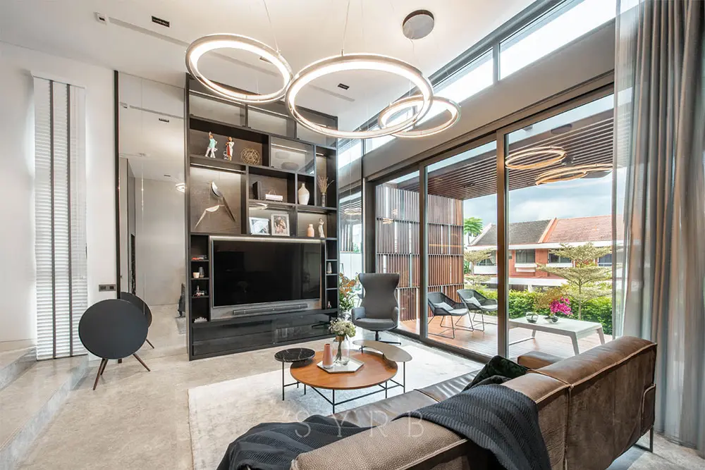 Living room with circular LED pendant lights and built-in shelving facing a terrace