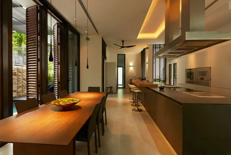 Open dining and kitchen space with louvered shutter doors and pendant lights