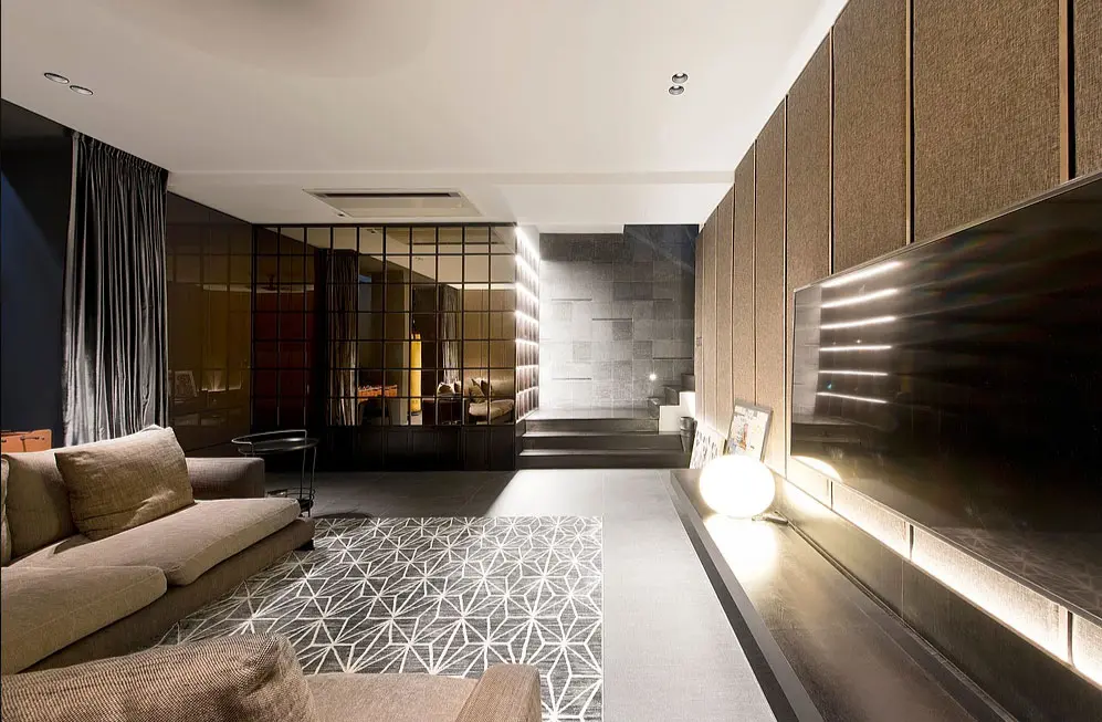 living room with mirrored partitions, a geometric rug and a wall-mounted TV