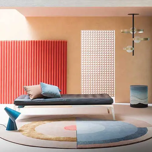 Lounge room with a ribbed orange wall panel, black daybed and pastel geometric rug