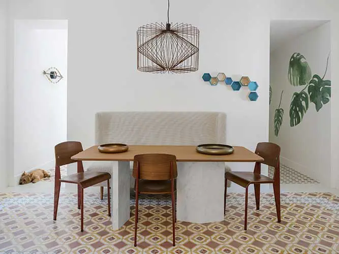 Dining room with a marble-base wood table, wire pendant light and hexagon wall decor