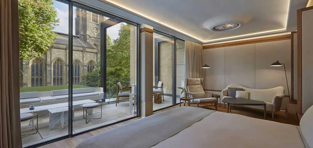Hotel bedroom with glass doors opening onto a courtyard facing a church
