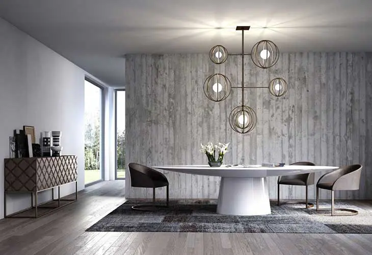 Dining room with round white table, gray chairs and a spherical orb chandelier