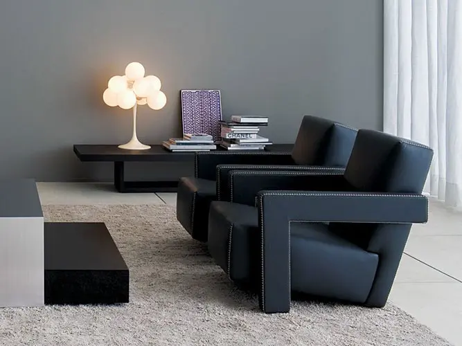 Living room with dark leather armchairs, a spherical table lamp and a shaggy rug