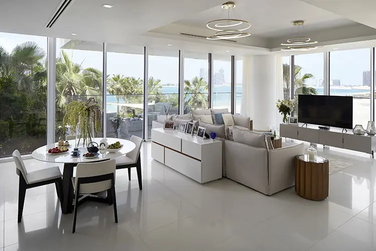 living room with sea view windows, white furniture and a round dining table