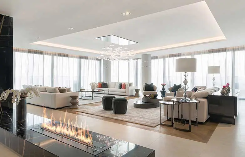 open-plan living room with white sofas, tall windows and a linear fireplace