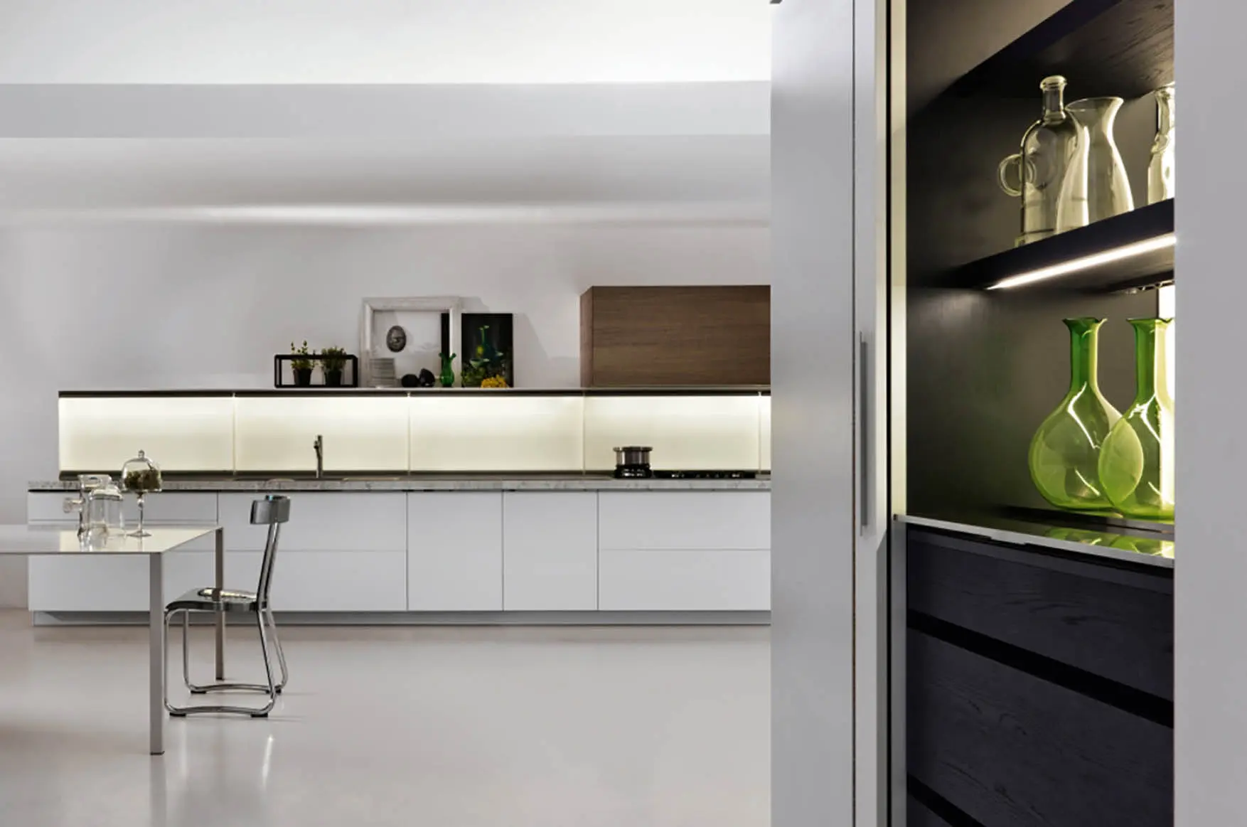 Dada Trim kitchen with white cabinetry, backlit counter panel, dark wood tall unit and dining table
