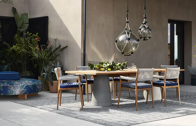 outdoor dining table with rope chairs and hanging glass pendant lights