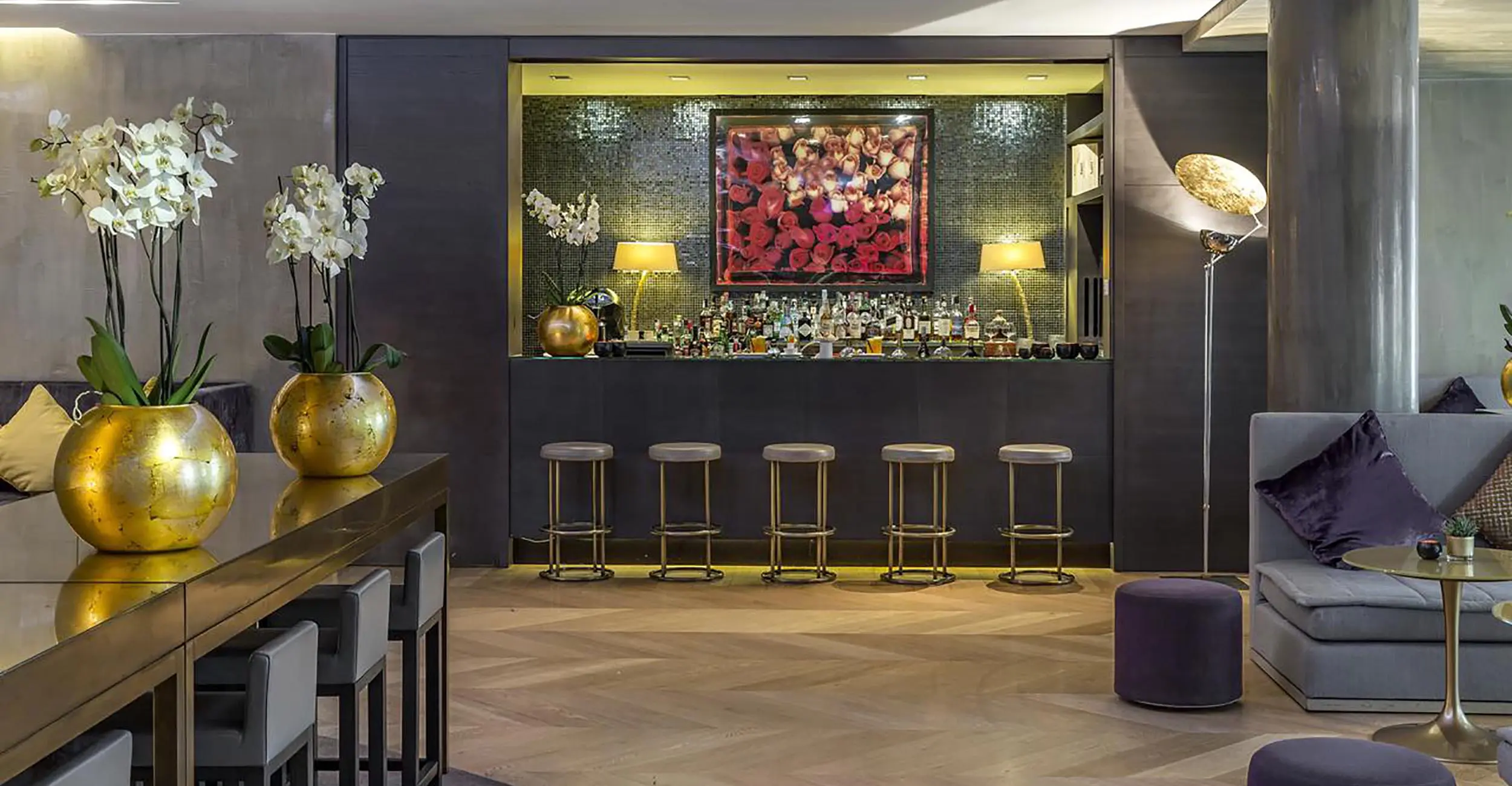 Hotel bar lounge with gold vases of orchids and bar stools