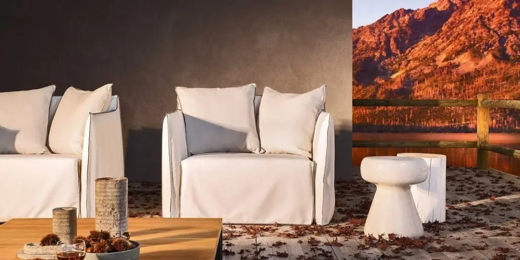 Gervasoni white slipcovered outdoor armchairs and a wood coffee table on a terrace