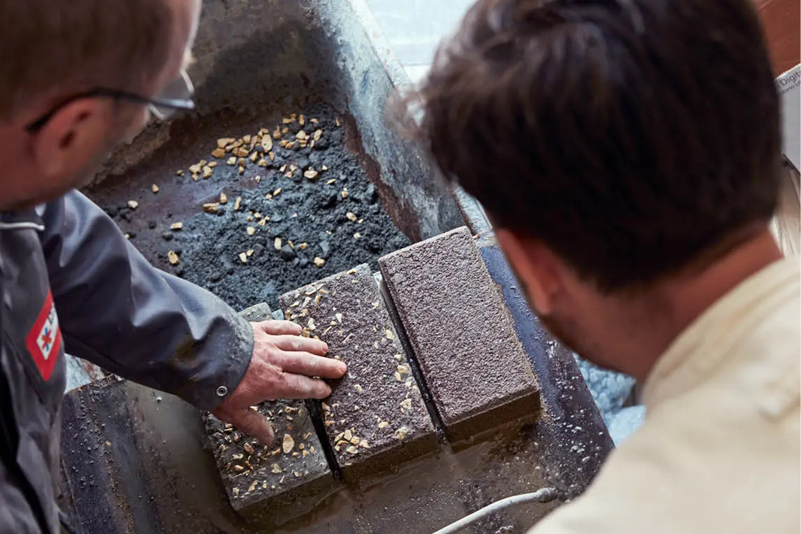Two craftsmen examining terrazzo-style stone blocks