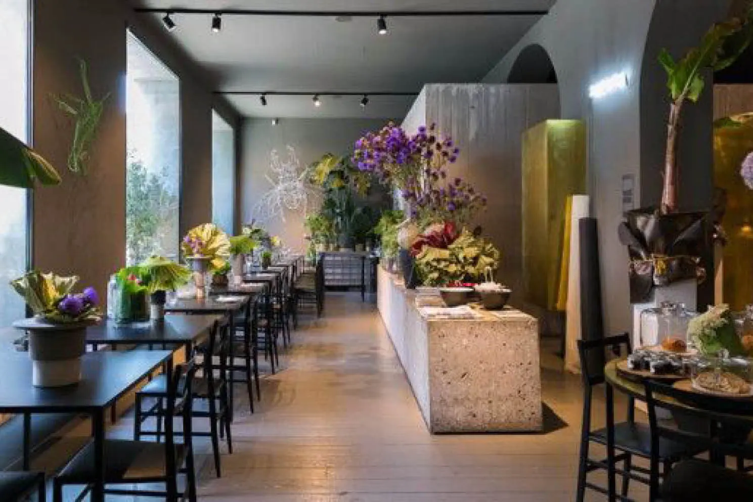 Long restaurant room with flower arrangements
