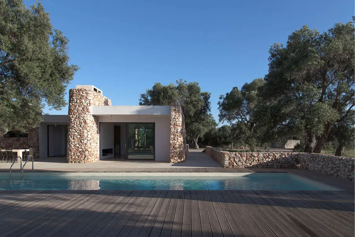 Single-storey villa with stone walls and a pool among olive trees
