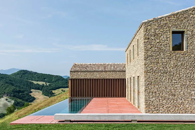 Stone farmhouse with an infinity pool overlooking green hills