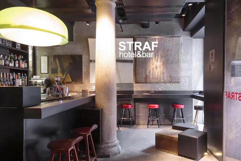 STRAF Hotel & Bar interior with red stools along a bar counter
