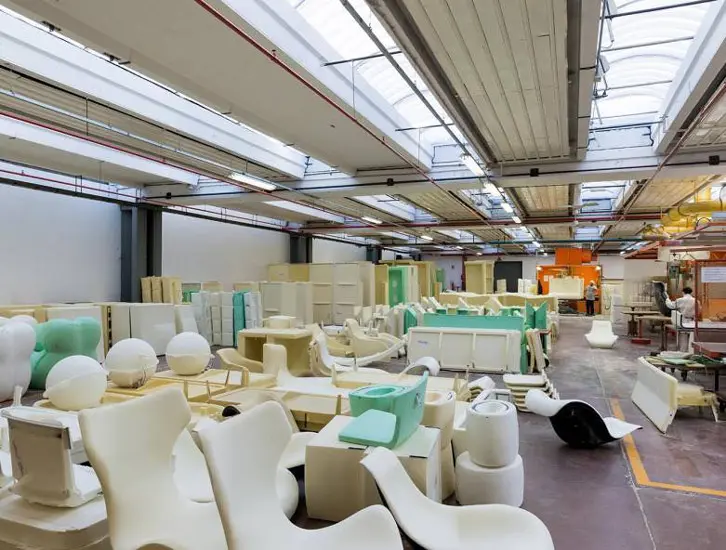 Warehouse filled with white and mint furniture prototypes under skylights