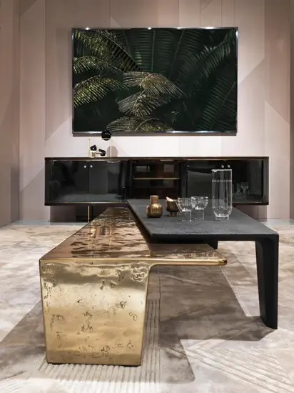 Living room vignette with a gold cube coffee table and a leafy artwork above a sideboard