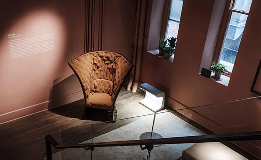 fan-shaped woven armchair displayed in a museum gallery setting