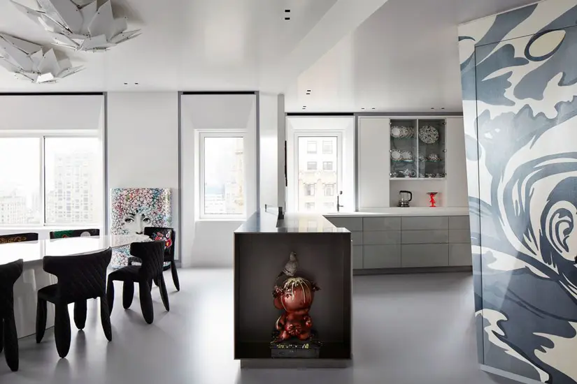 Kitchen and dining area with a marbled blue wall panel and a figurine on the island