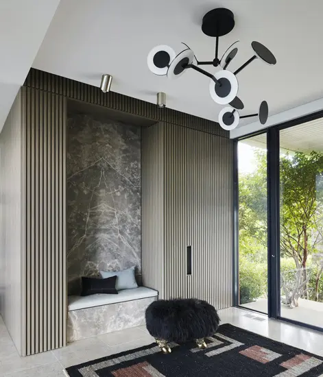 Alcove reading nook with a marble backsplash, a sculptural chandelier and a black stool