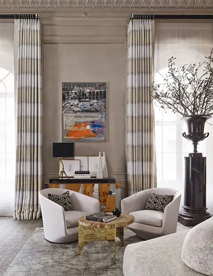 Sitting area with striped curtains, framed artwork and a floor vase with branches