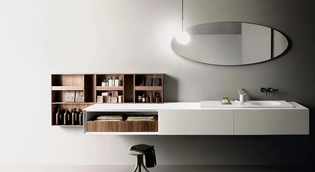 Floating bathroom vanity in white with an oval mirror and walnut wall cabinets